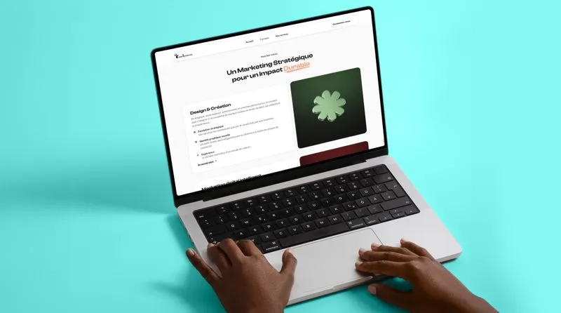 Hands typing on a laptop keyboard displaying a French webpage about strategic marketing with a green flower graphic on a turquoise background.